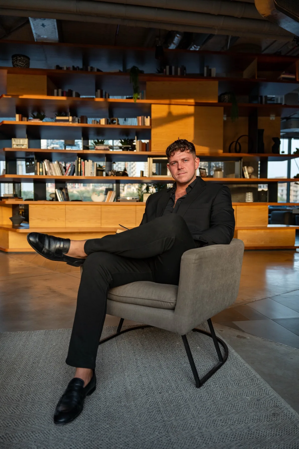 Tobias Schmidt, German real estate economist and founder of Schmidt and Partner, seated in a modern Dubai office with library shelves behind him